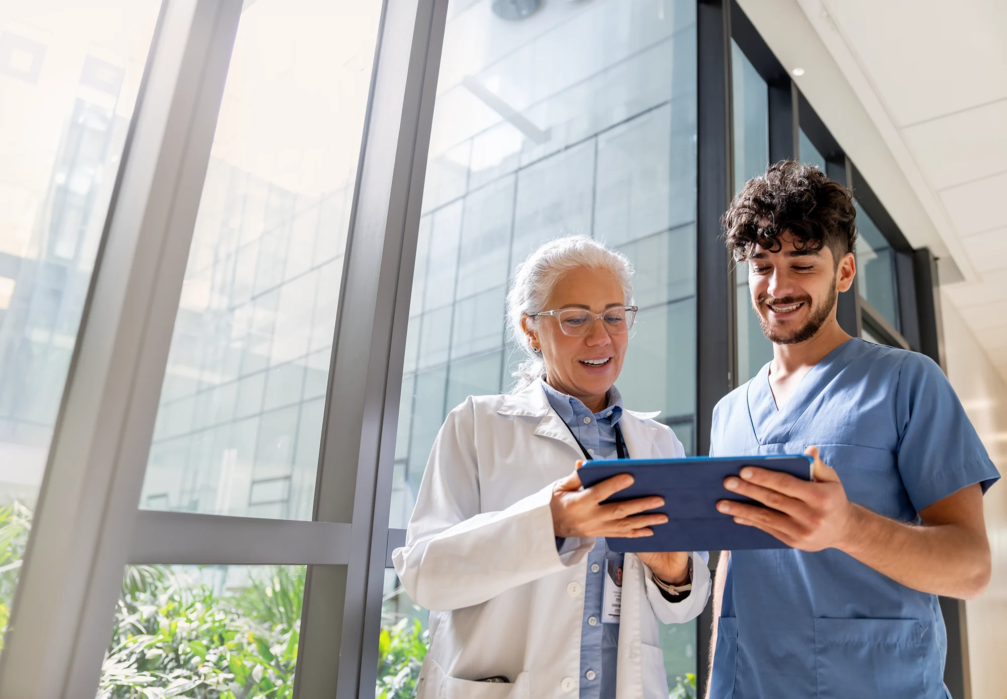 Doctor discussing test results with nurse using a digital tablet