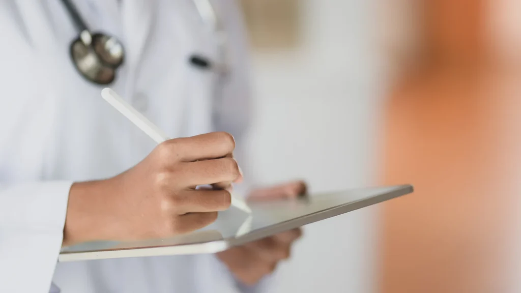 Cropped shot fo young female doctor working on medical records and exam results with tablet