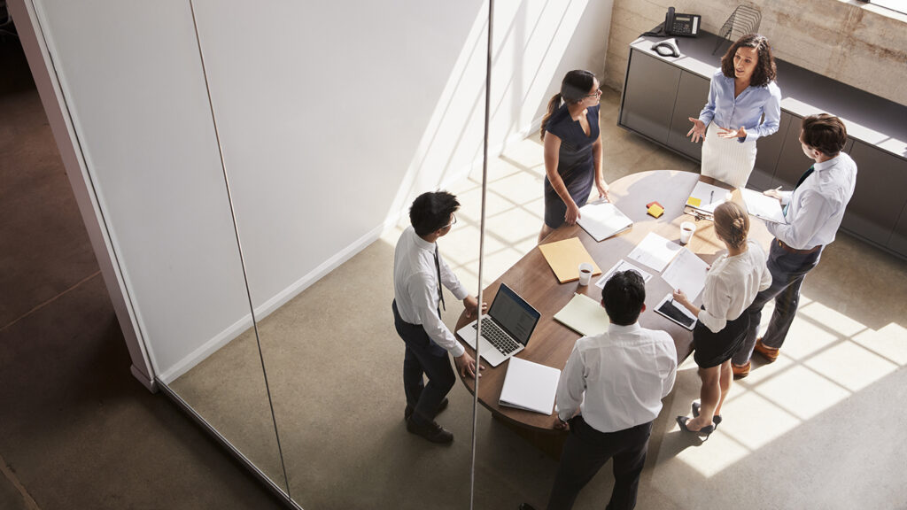 Female manager in team meeting, elevated view through window