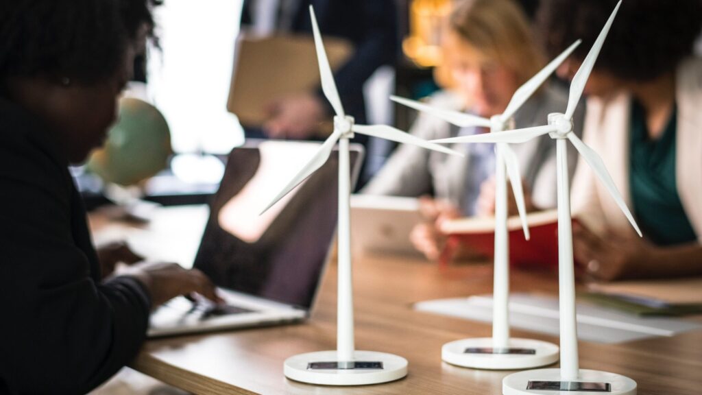 three miniature windmills on a table that is occupied by medical staff.